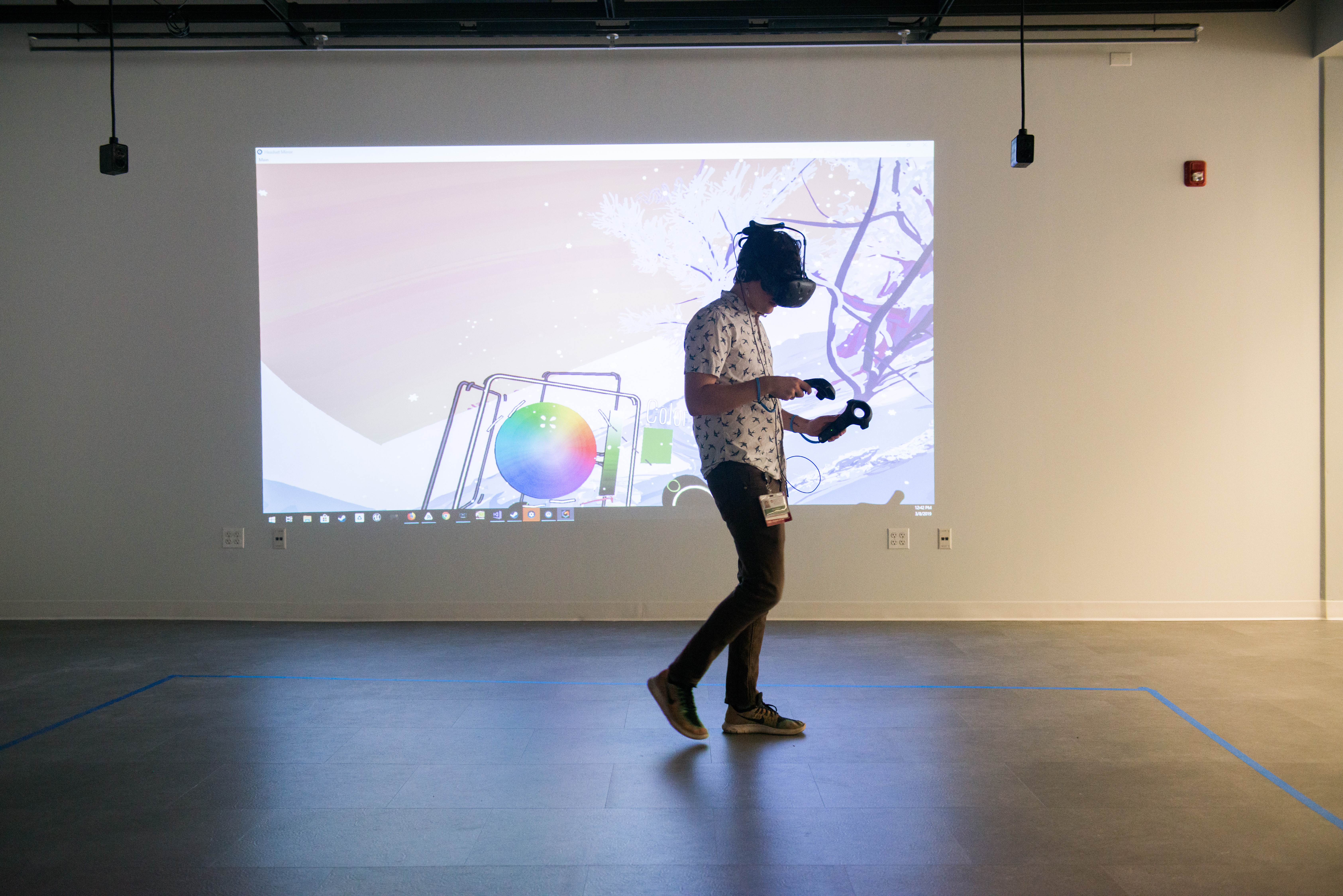 A person playing a virtual reality game while wearing a headset and holding two controllers. 